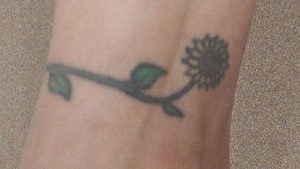tattoo of a rose and vine on right ankle