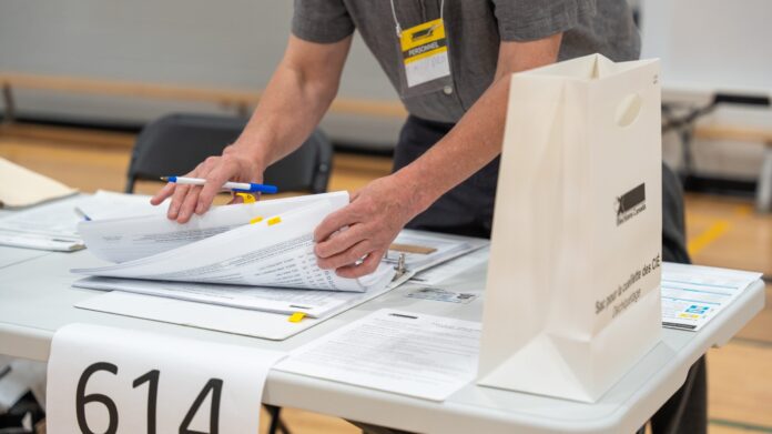 Poll worker serving an elector