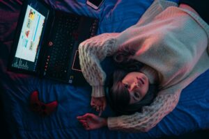 Young teen girl with laptop and gaming console looking up